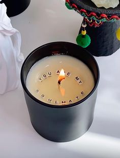 a candle with the words you are my soulmate written on it sitting next to other items