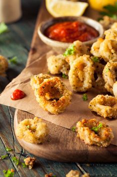 some fried food on a wooden board with ketchup