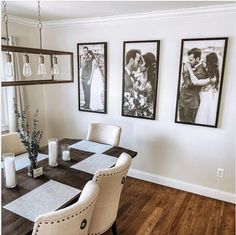 a dining room table with chairs and pictures on the wall