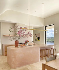 a large kitchen with an island counter and wooden chairs in front of the window that looks out onto the countryside