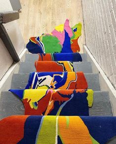 colorful rugs are lined up on the stairs