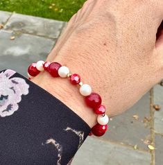 Red and white Swarovski pearl bracelet, stretch bracelet, gift ideas for her  Make a subtle statement with this gorgeous bracelet.  Wear alone of layer up with your current jewellery for a pop of colour to your look! This bracelet would make a lovely gift as easy to wear to and goes with absolutely everything!  Designed using quality Swarovski pearls in pearlescent white. Two different shades of red beads and crystals have been added along with tiny gold spacer beads which add a subtle shine and touch of luxury. This listing is for ONE bracelet and is the standard size of 7 inches. Should fit most wrist sizes due to the stretch elastic but please do let me know if you need a different size. Once purchased, I aim to get your item posted out to you within 1-2 business days. Your bracelet wil Red Polished Beads Bracelet For Gift, Red Pearl Bracelets As A Gift, Red White Bracelet, Playful Red Beaded Bracelets, Hand-strung Red Pearl Beaded Bracelets As Gifts, Swarovski Pearls Bracelet, Different Shades Of Red, White Bracelets, Gorgeous Bracelet