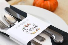 there is a place setting with silverware and napkins on the plate, along with an orange pumpkin