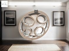 a circular sculpture in the middle of a room with pictures on the wall behind it