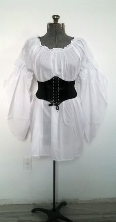 "UNIQUE CUSTOM STYLE, STAND OUT FROM THE CROWD! Versatile Chemise for all Your Costume Needs On or Off shoulders 100% Cotton 32\" Long Chemise Elastic neckline, On or Off Shoulder Long Flowing Sleeves with 2 Elastic Puffs, On Or Off Shoulder *SUPER VERSATILE* YOU'LL LOVE THIS CHEMISE FOR ALL YOUR RENAISSANCE, PIRATE, STEAMPUNK, WENCH, PEASANT OR MERCHANT COSTUMES. PERFECT FOR FAIRES, PLAYS, CIVIL WAR REENACTMENTS, EDWARDIAN, VICTORIAN & BOHO FESTIVALS AND MUCH MORE! SIZES Regular US Women's Puffy Blouse, Victorian Boho, Brown Corset, Ren Faire Costume, Pirate Woman, Long Skirt Outfits, Victorian Costume, Boho Festival, 20's Dress