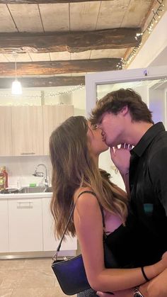 a man and woman kissing in the kitchen