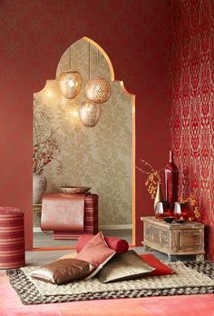 a living room with red walls and decorative items on the floor in front of it