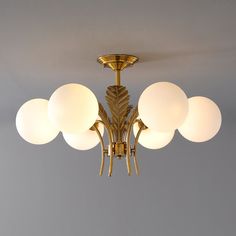 a chandelier with five globes hanging from it's ceiling light fixture