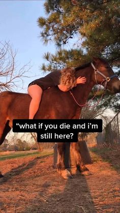 a woman standing next to a brown horse on top of a grass covered field with trees in the background