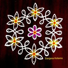 an image of some white and yellow flowers on a red tablecloth with the words saniya kolams written in it