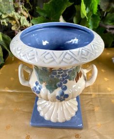 a blue and white vase sitting on top of a table next to a planter