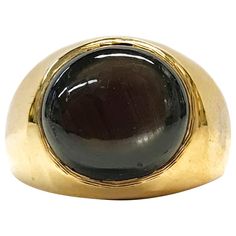 14 Karat Round Black Star Sapphire Ring. The ring features a bezel-set round black star sapphire. The six-star sapphire has great presence with light. The sapphire measures 12mm and the ring size is 6 3/4. The ring has a smooth shiny finish with a tapered band. The total gold weight of the ring is 16.7 grams. Black Star Sapphire Ring Vintage, Dome Rings, Black Star Sapphire, Star Sapphire Ring, Star Sapphire, Domed Ring, Black Star, Jewelry Inspo, Estate Jewelry