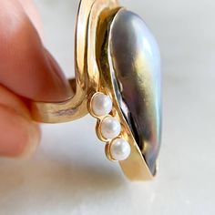 Vintage Baroque Pearl Cocktail Ring 14K Yellow Gold Baroque Pearl 30.2x13.9mm 7.9gm Size 7 sizing available with fee contact us to have it added to the price before checkout. Thank you for visiting our shop! 𝑫𝑴𝑲 𝑱𝒆𝒘𝒆𝒍𝒓𝒚 Elegant Cabochon Teardrop Ring, Elegant Teardrop Cabochon Ring, Unique Pear-shaped Gold Rings, Elegant Handmade Pear-shaped Ring, Unique Gold Oval Pearl Ring, Elegant Handmade Teardrop Ring, Pearl Cocktail Ring, Pearl Vintage, Gold Baroque