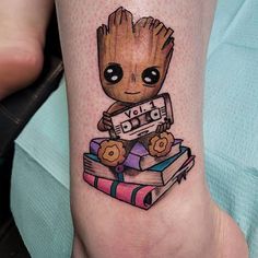 a small tattoo on the leg of a person with a book and baby groote