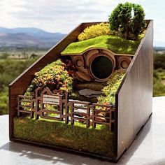 a house made out of wood with grass growing on the roof and in the shape of a hobbot