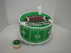 a football themed birthday cake with a cupcake next to it on a white surface