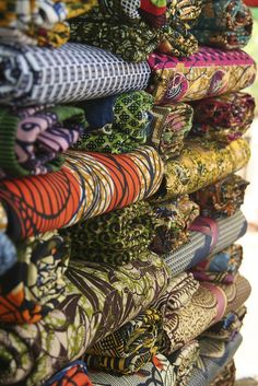 many different colored ties are stacked on top of each other in the same pattern and color