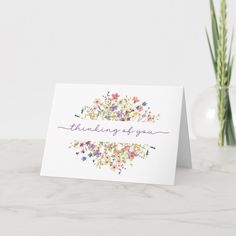 a card with the words thinking is you written on it next to a vase filled with flowers