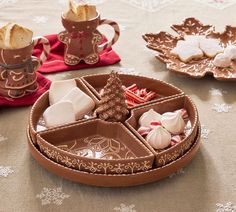 three trays filled with different types of food on top of a cloth covered table