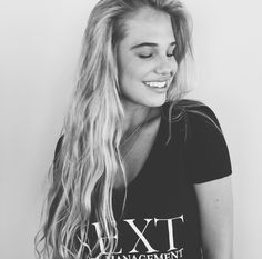 a woman with long blonde hair wearing a t - shirt that says xxt management