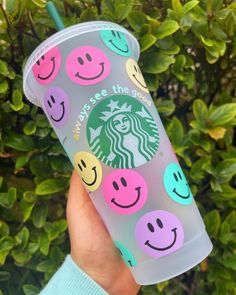 someone holding up a starbucks cup with smiley faces on it