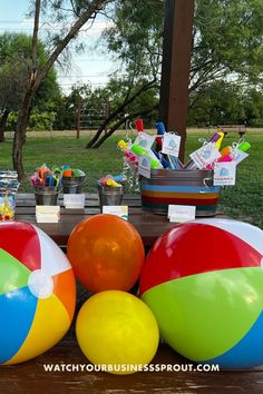 an assortment of beach balls on a picnic table