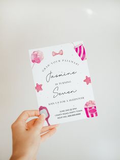 a person holding up a card with a pink bow on it