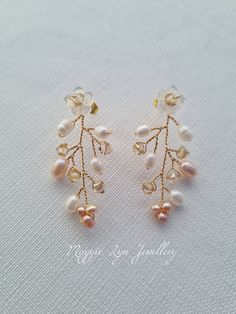 Truly beautiful bridal earrings, with a drop of approximately 4.5cm. Handmade with hand carved Mother of pearl flowers, quality natural ivory and blush pink freshwater pearls with the finest quality champagne crystals set on a Gilt gold plated, copper wire showing intricate detailing. All of our items are made to order so adjustments can be made with regards to materials and designs. Please message us if you require different specifications.  The design is handmade featuring natural freshwater p Handmade Delicate Pearl Earrings, Elegant Handmade Crystal Earrings For Wedding, Elegant Handmade Crystal Wedding Earrings, Pearl White Clip-on Earrings With Pearl Drop For Wedding, Gold Flower Cluster Earrings For Wedding, Delicate Crystal Drop Earrings, Elegant Gold Flower-shaped Beaded Earrings, Elegant Gold Flower Beaded Earrings, Delicate Pearl Drop Dangle Crystal Earrings