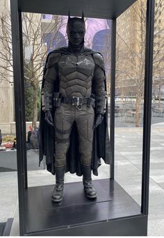 a batman costume is displayed in a glass case