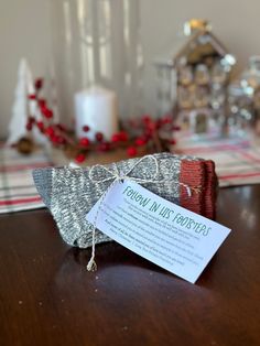 a small piece of fabric sitting on top of a wooden table next to a candle