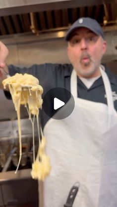 a man in an apron is holding some food