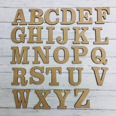 the letters are cut out of wood and placed on a white wooden surface with scissors