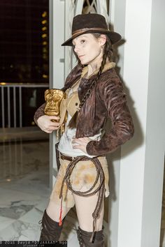 a woman dressed in steampunk clothing holding a trophy