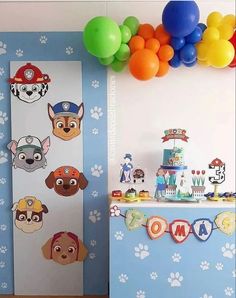 a birthday party with paw patrol decorations, balloons and streamers on the wall for kids to play in