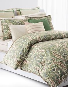 a bed with green and white comforters on top of it