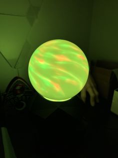 a person is holding a glowing object in their hand and it's glows green