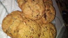 a pile of cookies sitting on top of a white plate next to a glass bowl