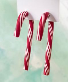 two candy canes hanging from a white sign