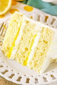 a piece of cake on a plate with a fork and lemon wedges next to it