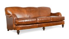 a brown leather couch sitting on top of a wooden table