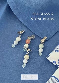 sea glass and stone beads are displayed on a blue shirt