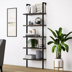 a book shelf with books and plants on it next to a plant in a vase