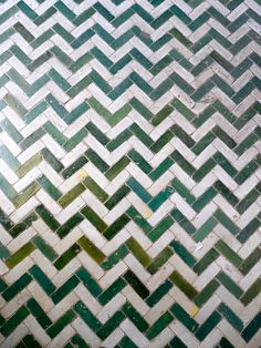 an old tile floor with green and white herringbones inlayed to it