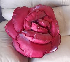 a pink rose sitting on top of a white couch