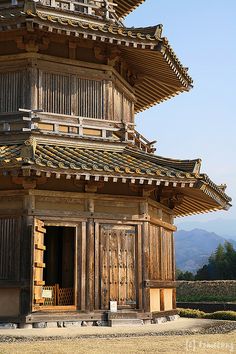 a tall wooden building with lots of windows on it's sides and an open door at the top