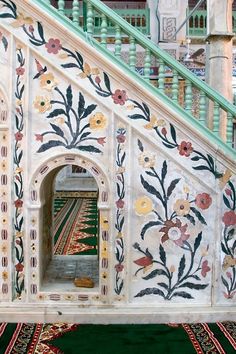 the stairs are decorated with floral designs and rugs on green carpeted flooring