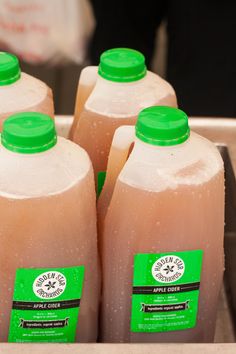 four bottles of juice sitting on top of a metal tray next to eachother