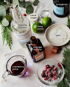 ingredients to make cranberry sauce sitting on a white table with green leaves and bottles