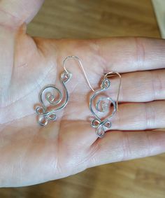 "Sterling silver 18 gauge wire is swirled and looped into this Celtic influenced spiral earrings design. We hammered the earrings for extra strength and character. These very light weight earrings are great every day! The entire earring measures about 1 1/8- 1 3/8\" (2.9- 3.4 cm) from the top loop to the bottom of the earrings. The earwire adds about 1/2\" maiking them a total length of about 1 5/8-1 7/8\" (4.1-4.8cm) from the top of the earwire to the bottom of the earring. It is about 1/2\" (1 Silver Wire Earrings, Celtic Spiral, Celtic Earrings, Bijoux Fil Aluminium, Chain Maille, Spiral Earrings, Earrings Women, Wrapped Jewelry, Wire Work