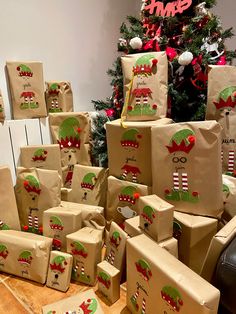 many presents are wrapped in brown paper with green and red designs on them next to a christmas tree